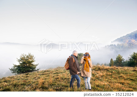 Senior couple on a walk in an autumn nature. 35212024