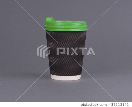 Black paper coffee Cup with a green lid. On a gray Black paper coffee Cup with a green lid. On a gray 35213141