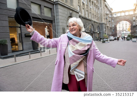 Romantic senior lady enjoying walk in town 35215317