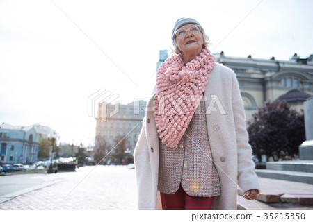 Happy senior woman enjoying pleasant walk in city Happy senior woman enjoying pleasant walk in city 35215350