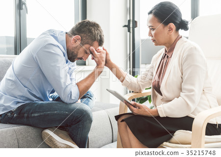 Serious female psychologist sitting near man Serious female psychologist sitting near man 35215748