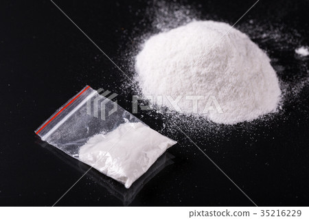 Cocaine in plastic packet on black background Cocaine in plastic packet on black background 35216229
