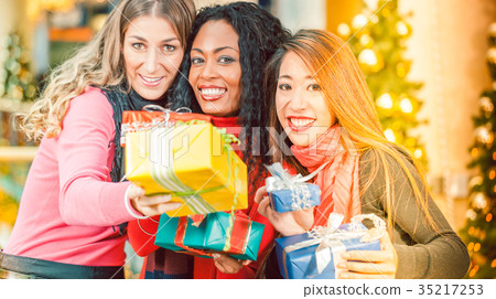 Friends Christmas shopping with presents in mall Friends Christmas shopping with presents in mall 35217253