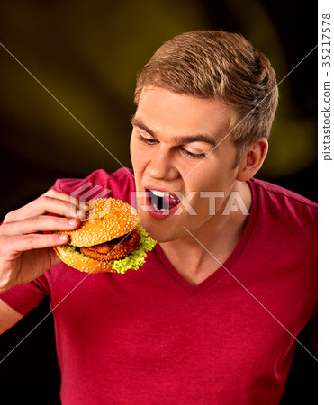 Man eat hamburger. Fastfood and junk food concept. Man eat hamburger. Fastfood and junk food concept. 35217578