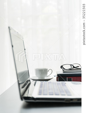 Laptop placed on desktop with coffee cup Laptop placed on desktop with coffee cup 35221503