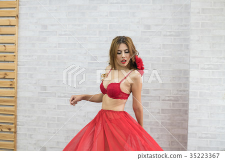 Woman in sexy red swimsuit poses in bedroom. 35223367