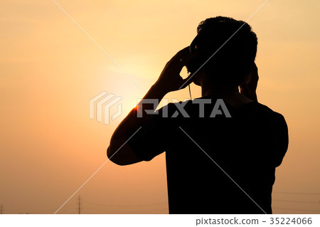 Man silhouette listening headphones on the sunset  35224066