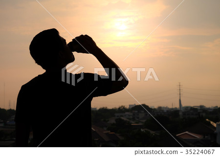 silhouette of a man drinking a can of beer silhouette of a man drinking a can of beer 35224067