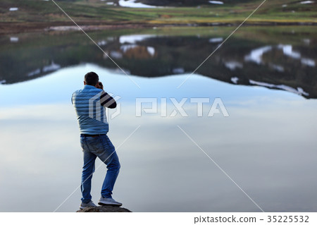 Landscape photographer photographing mountain lake 35225532