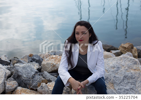 woman dressed in nautical style sitting by seaside woman dressed in nautical style sitting by seaside 35225704