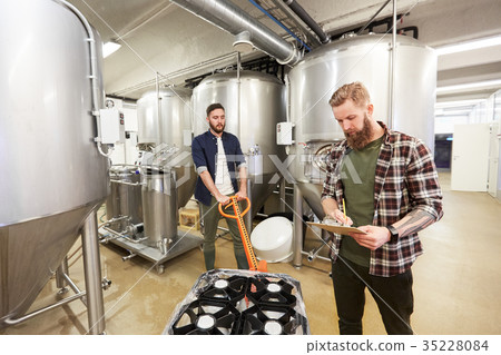 men with beer kegs on loader at craft brewery 35228084