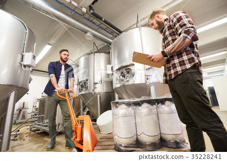 men with beer kegs and clipboard at craft brewery 35228241