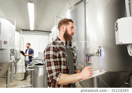 men with clipboard at craft brewery or beer plant 35228265