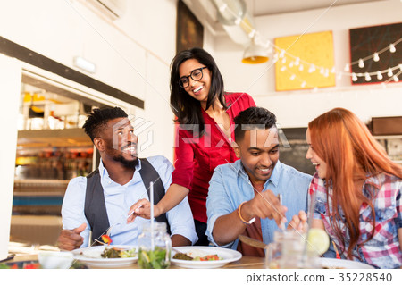 happy friends eating at restaurant happy friends eating at restaurant 35228540