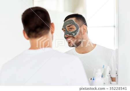 young man with clay mask on face at bathroom 35228541