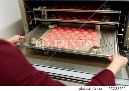 chef with macarons on oven tray at confectionery chef with macarons on oven tray at confectionery 35228551