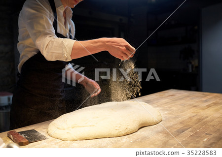 chef or baker making bread dough at bakery 35228583