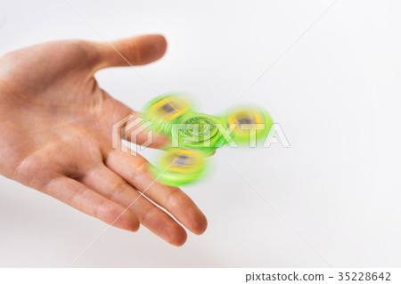 close up of hand playing with fidget spinner 35228642