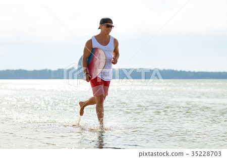 happy young man with skimboard on summer beach happy young man with skimboard on summer beach 35228703