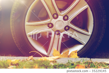 close up of car wheel and autumn leaves 35229145