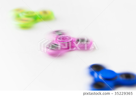 three spinning fidget spinners on white background 35229365
