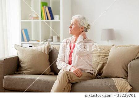 senior woman suffering from neck pain at home 35229701
