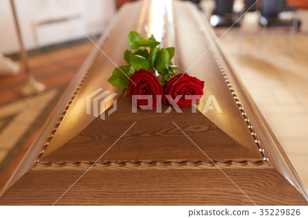 red rose flowers on wooden coffin in church 35229826