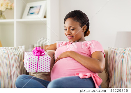 happy african american pregnant woman with gift happy african american pregnant woman with gift 35229836