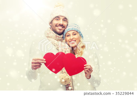 smiling couple in winter clothes with red hearts smiling couple in winter clothes with red hearts 35229844
