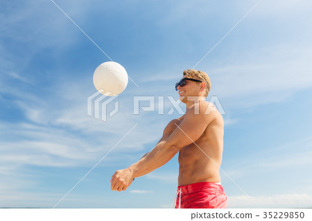 young man with ball playing volleyball on beach young man with ball playing volleyball on beach 35229850