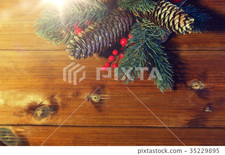 close up of fir branch with cones on wooden table 35229895