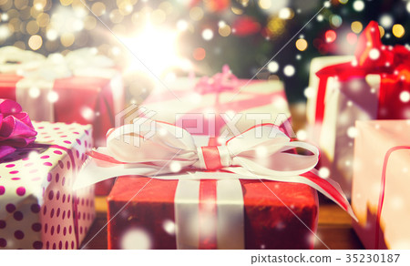 close up of gift boxes over christmas tree lights close up of gift boxes over christmas tree lights 35230187