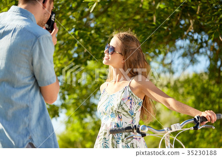 man photographing woman with bicycle by camera 35230188