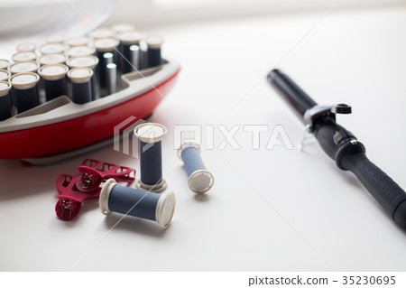 hot rollers kit on table with hair clips and iron 35230695