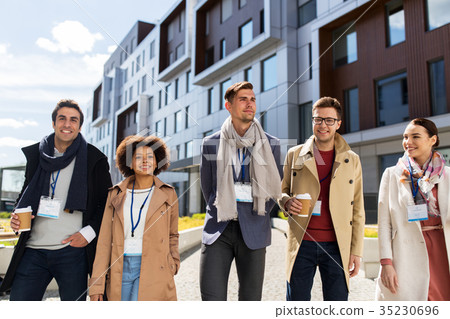 people with coffee and conference badges in city people with coffee and conference badges in city 35230696