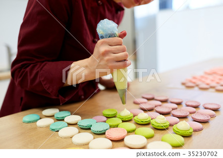 chef with injector squeezing filling to macarons chef with injector squeezing filling to macarons 35230702