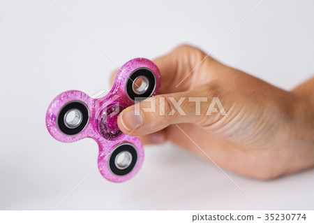 close up of hand playing with fidget spinner 35230774
