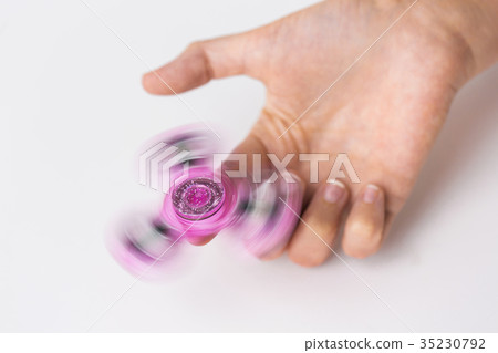 close up of hand playing with fidget spinner 35230792