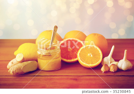 honey, citrus fruits, ginger and garlic on wood 35230845