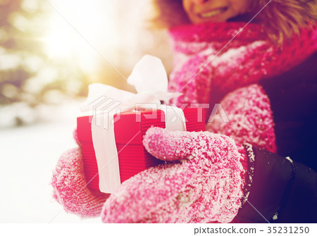 close up of woman with christmas gift outdoors close up of woman with christmas gift outdoors 35231250