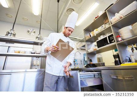 chef with clipboard doing inventory at kitchen 35231350
