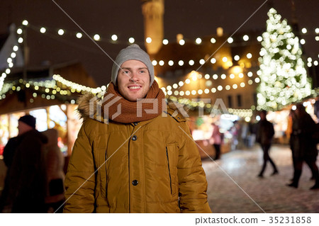 happy young man at christmas market in winter happy young man at christmas market in winter 35231858
