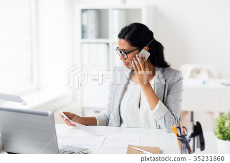 businesswoman calling on smartphone at office businesswoman calling on smartphone at office 35231860