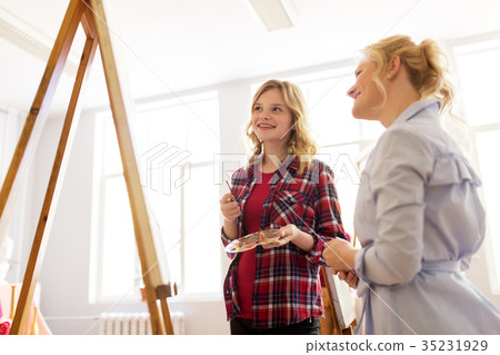 artists discussing painting on easel at art school artists discussing painting on easel at art school 35231929