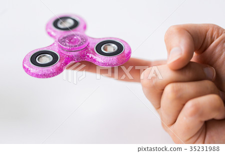 close up of hand playing with fidget spinner 35231988