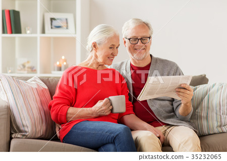 happy senior couple reading newspaper at christmas happy senior couple reading newspaper at christmas 35232065