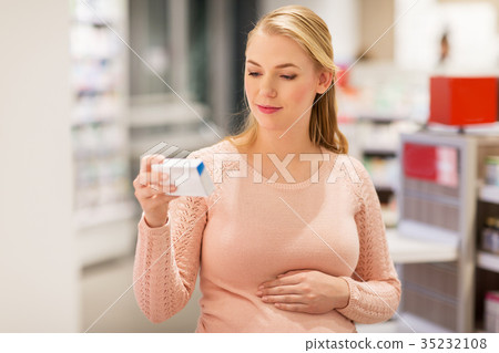 happy pregnant woman with medication at pharmacy 35232108
