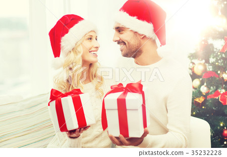 happy couple at home exchanging christmas gifts happy couple at home exchanging christmas gifts 35232228