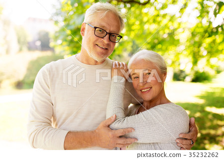 happy senior couple hugging at summer park happy senior couple hugging at summer park 35232262