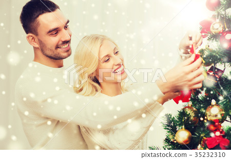 happy couple decorating christmas tree at home happy couple decorating christmas tree at home 35232310
